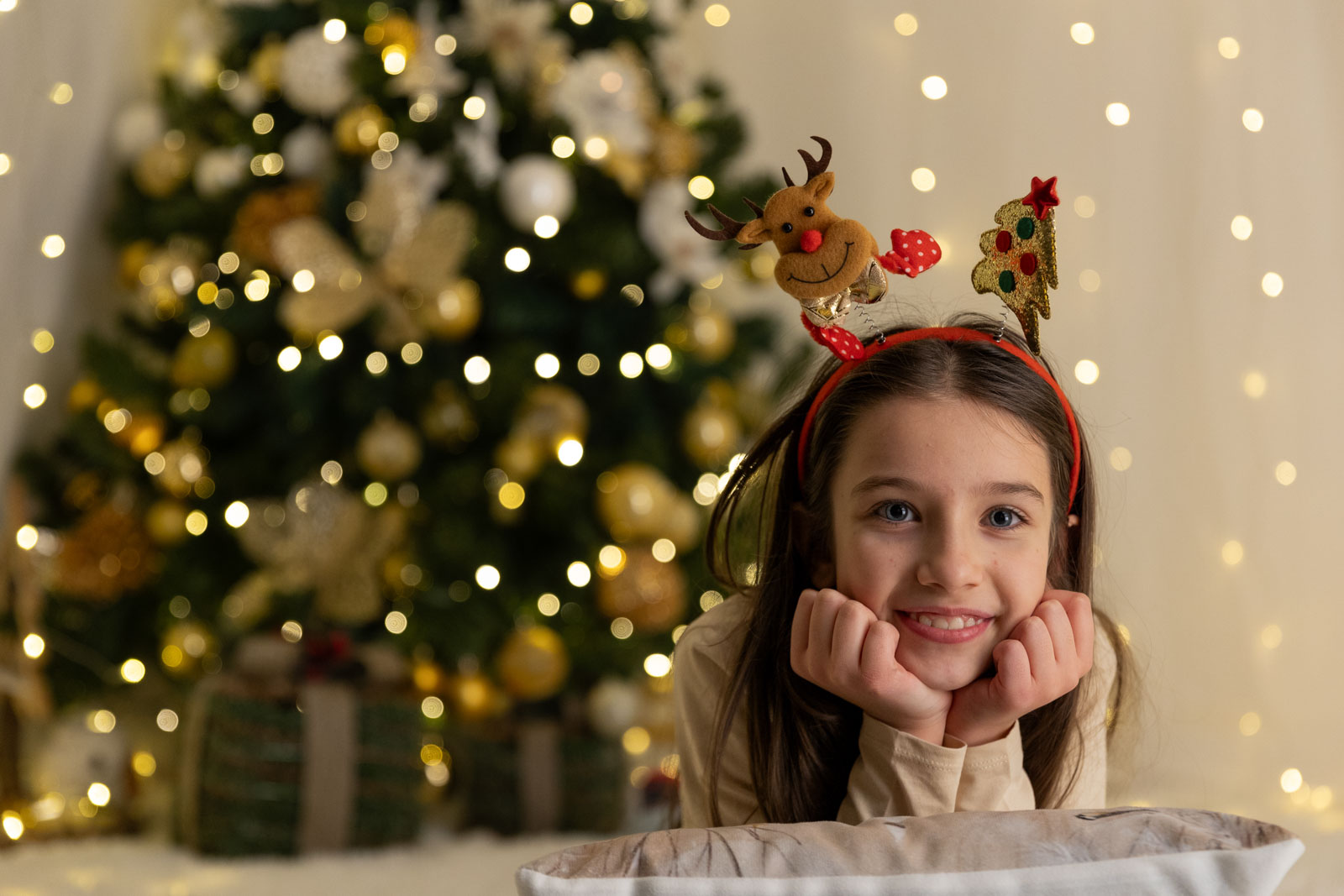 Bambina sotto l'albero durante un servizio fotografico natalizio