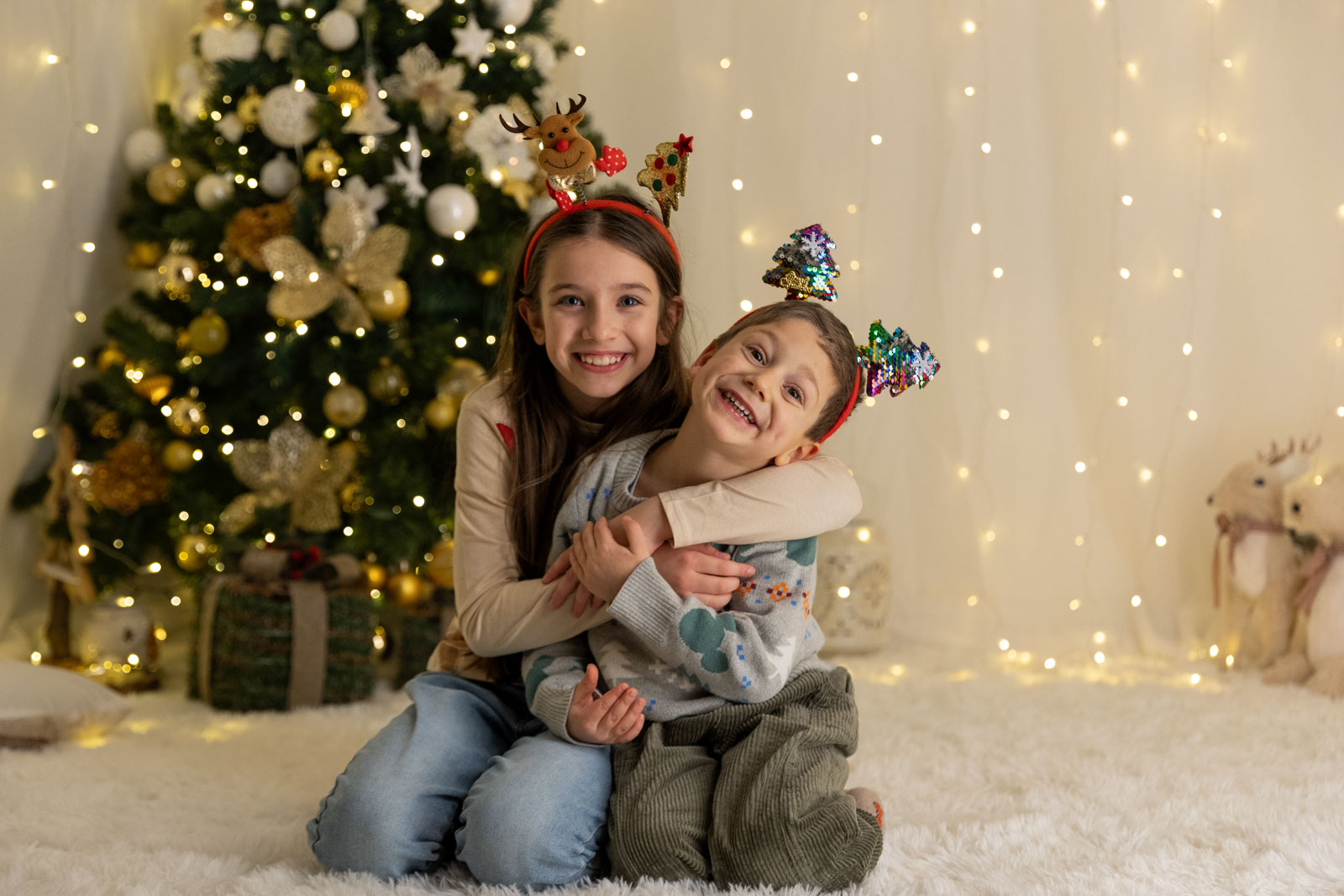 Fratelli ridono con sfondo un albero di Natale