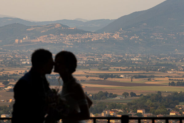 Gli Sposi si baciano a Bettona con sfondo Assisi