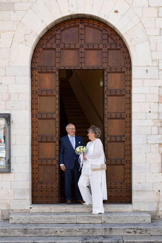 Coppia di Sposi adulti davanti alla porta del comune di Assisi