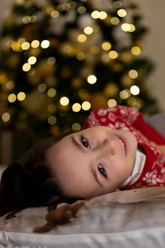 foto in verticale di una bambina con sfondo un albero di Natale a Petrignano