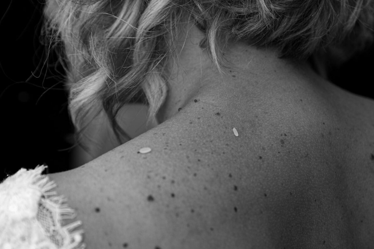 foto in bianco e nero di chicchi di riso sulla schiena di una Sposa a Corciano (Perugia)