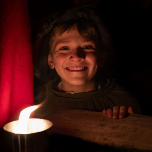 bambino si scalda al calore di una torcia