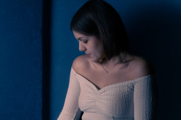 ragazza mora guarda in basso durante uno shooting in studio