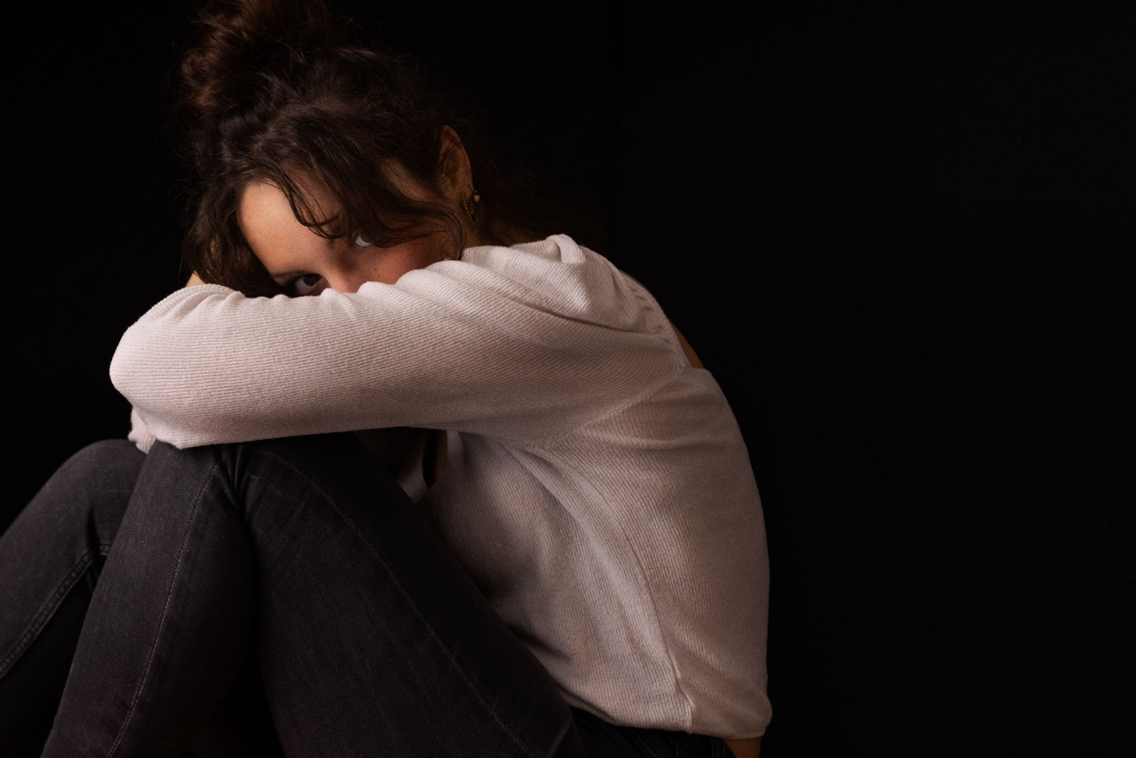 Servizio fotografico ad una ragazza con maglione bianco che si copre il viso